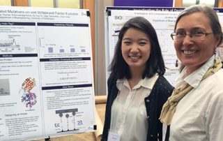 Wendy Thomas with student next to research poster