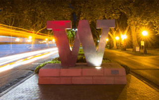 Bronze W statue at night