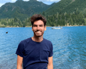 Jamison Siebart standing in front of lake with mountains in background