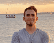 Osvaldo Arias in front of lake with sailboats