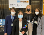 Four students holding device at tradeshow-style competition
