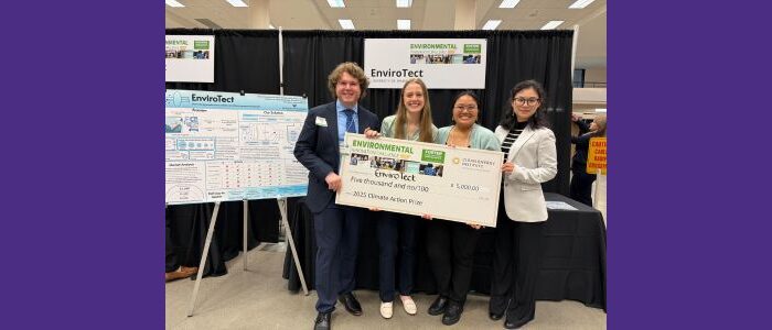 UW Bioengineering Master of Applied Bioengineering students standing next to their project board holding a giant check for $5000 from the Environmental Innovation Challenge competition. Students left to right are Kaitlin O’Keefe, Evan Smith, Mariah Estira and Amy Yang.