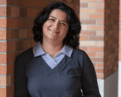 Azadeh Yazdan standing near brick columns
